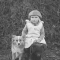 Historisches Foto von Kind, das neben einem Hund sitzt