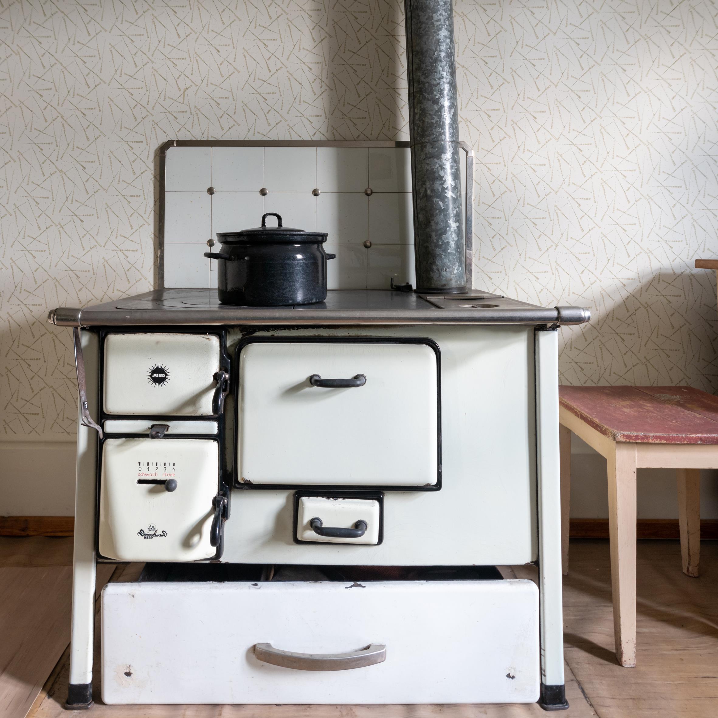 Historischer Herd zum Kochen mit Holz, mit Kochtopf und Ofenrohr